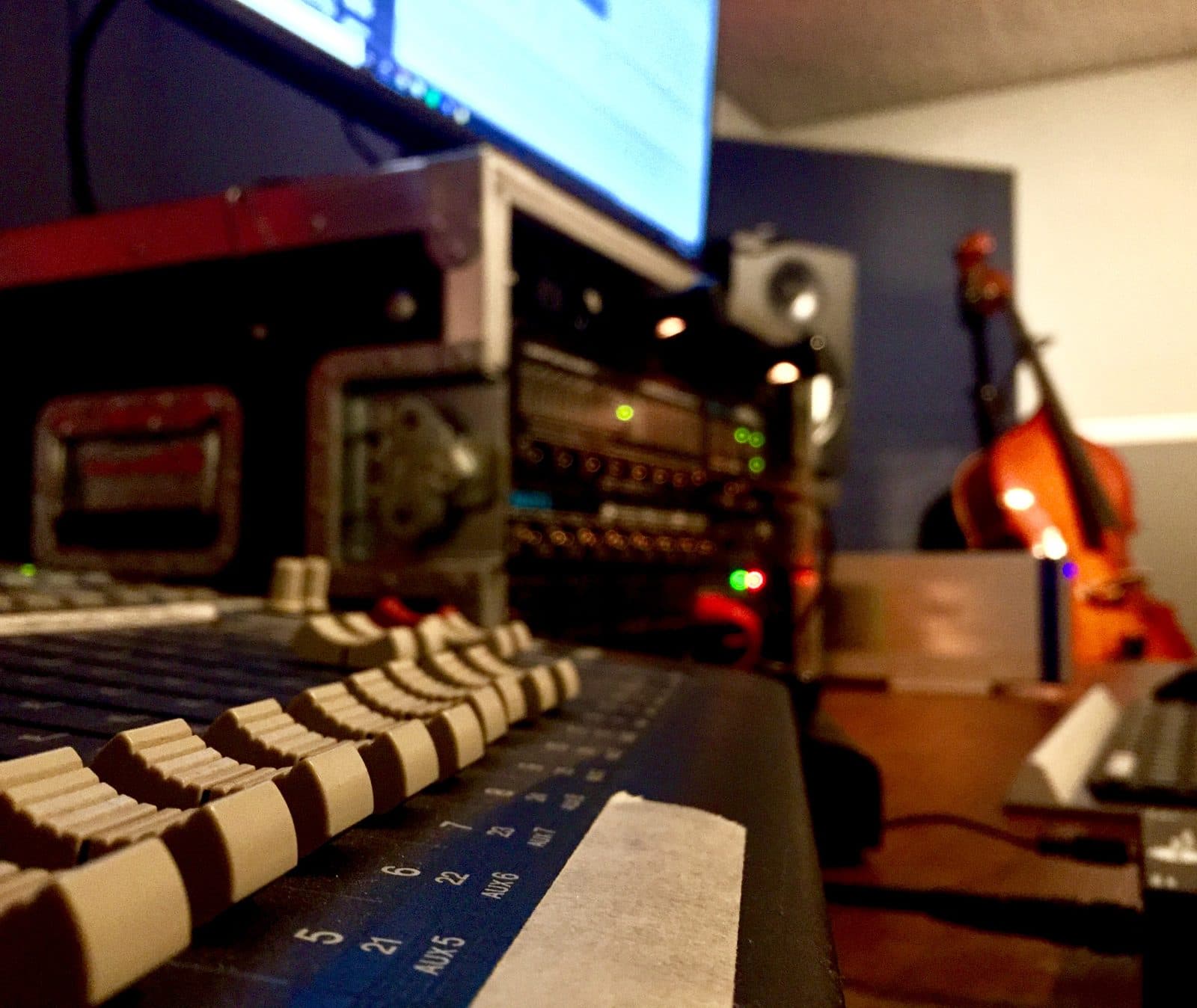 Mixing console faders and outboard gear in the control room